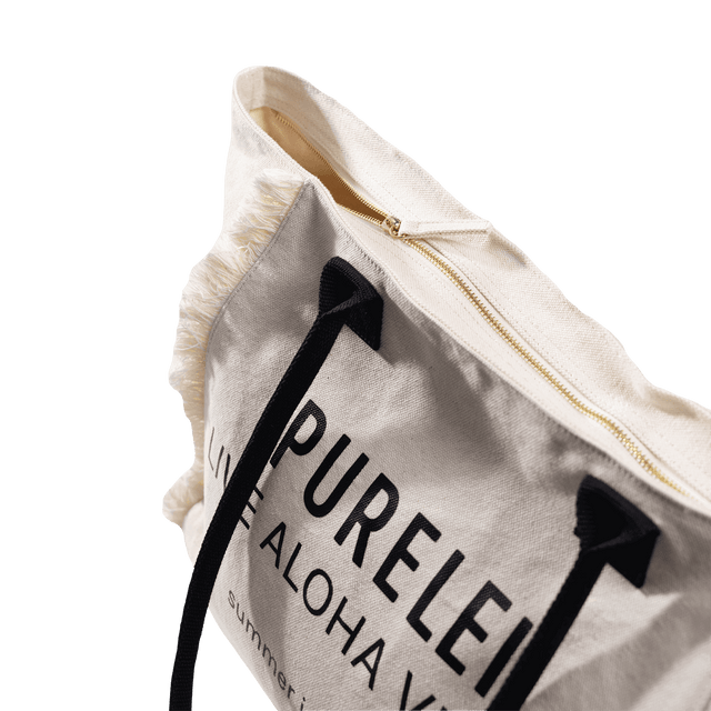 Helle PURELEI Tasche aus Baumwolle mit Reißverschluss und fransigem Design.