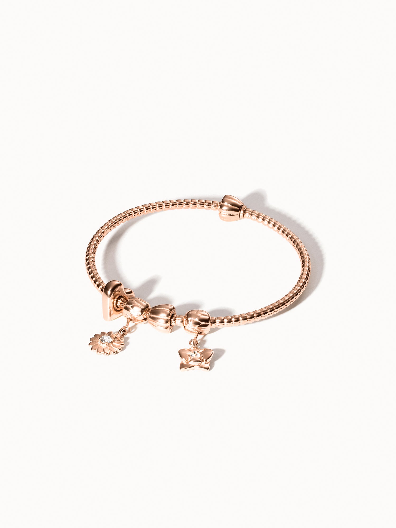 Roségoldener Lei Charm Armreif mit zwei Stopper-Charms, filigranes Blumenmotiv, elegant und feminin von PURELEI.