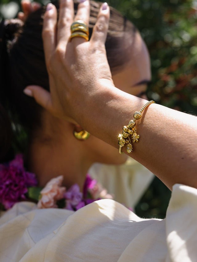 Goldener Lei Kleeblatt Bubble Charm, 14K vergoldet, als eleganter Glücksbringer am sonnigen Handgelenk von PURELEI