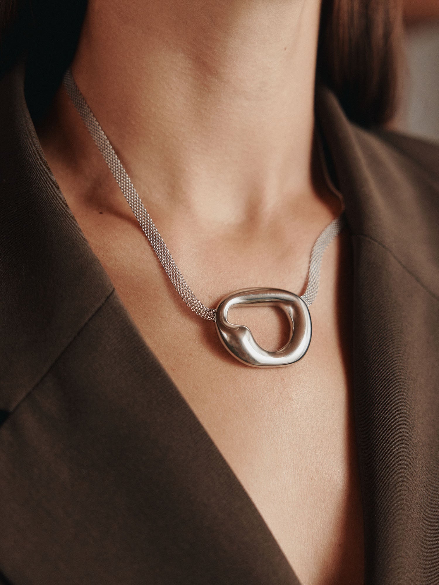 Silberne Kette mit organischem Anhänger, elegant getragen, inspiriert von PURELEI.