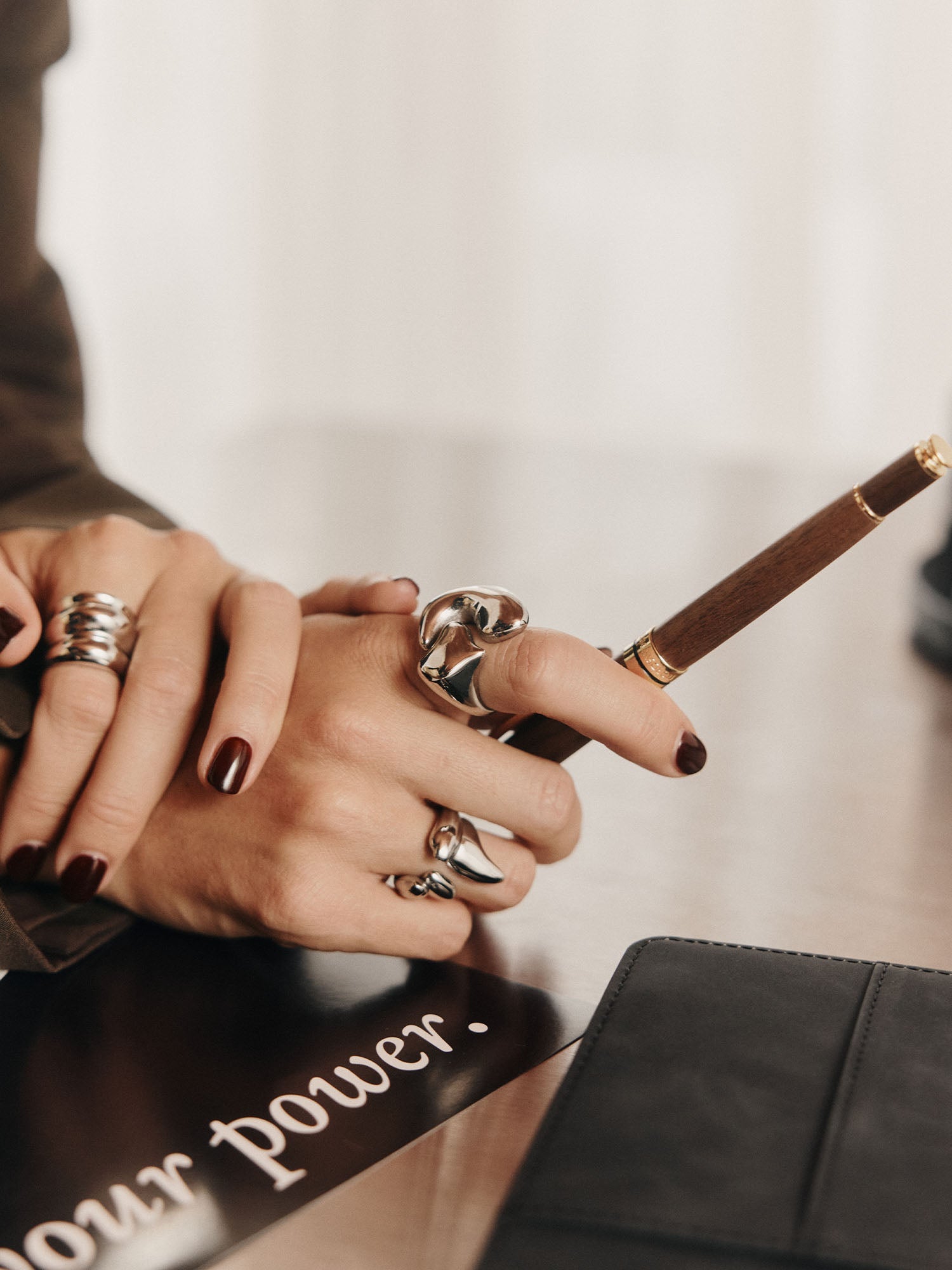 Silberne Ringe an einer Hand mit dunklem Nagellack, PURELEI inspiriert von Eleganz.