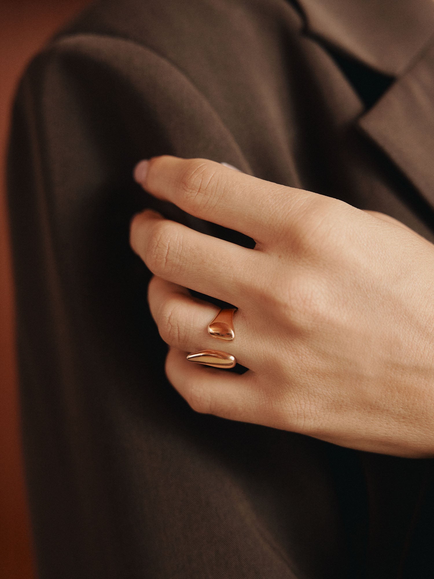 Roségoldener Ring mit geschwungenem Design, getragen an einer Hand, inspiriert von PURELEI.