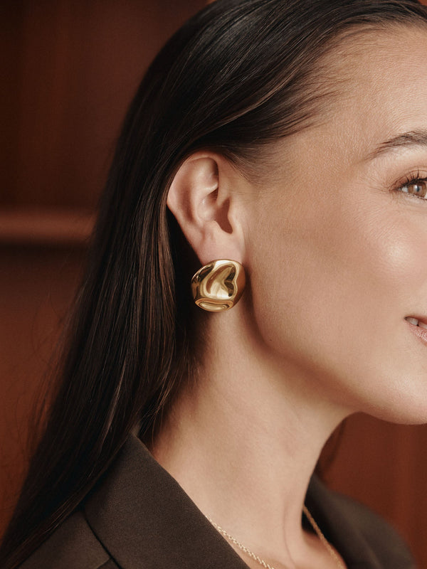 Elegante, roségoldene Ohrringe mit geschwungenem Design, getragen von einer Frau, PURELEI.