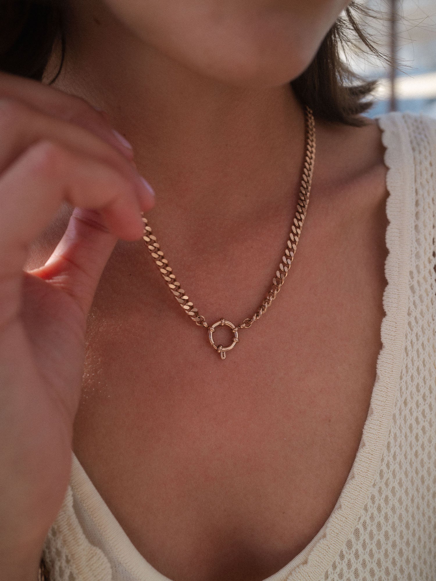 PURELEI Bold Charm Kette in Gold mit Charm-Verschluss, markant und feminin am Dekolleté getragen.