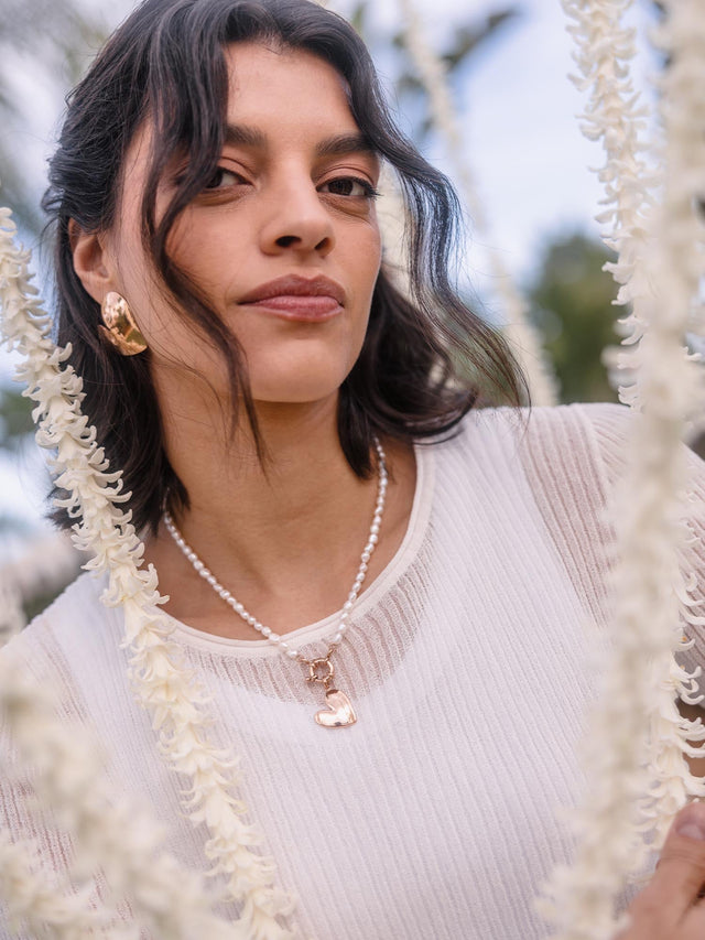 Perlenkette mit Herz-Anhänger, getragen von einer Frau, PURELEI inspiriert.