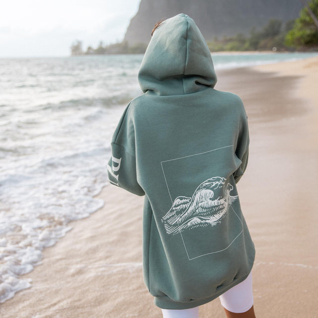 Locker sitzender grüner Wave Hoodie von PURELEI mit Wellenmotiv auf dem Rücken, naturverbunden und entspannt.