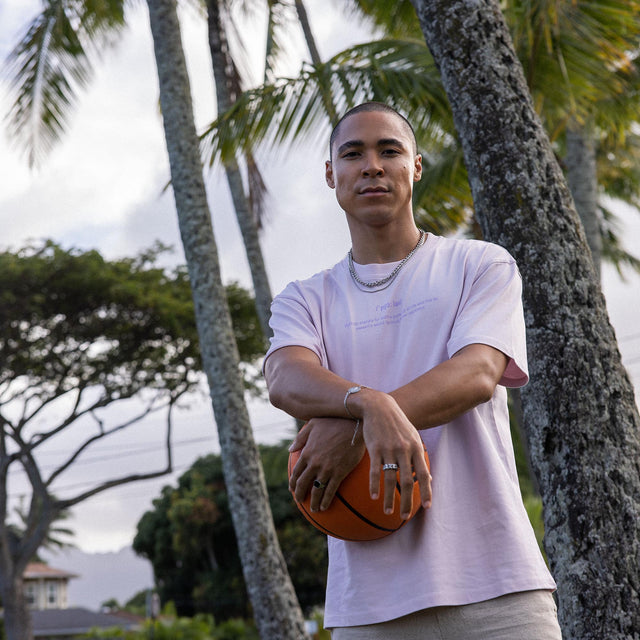Moderne PURELEI Schmuckstücke, getragen im Freien, umgeben von Palmen und sportlicher Atmosphäre.