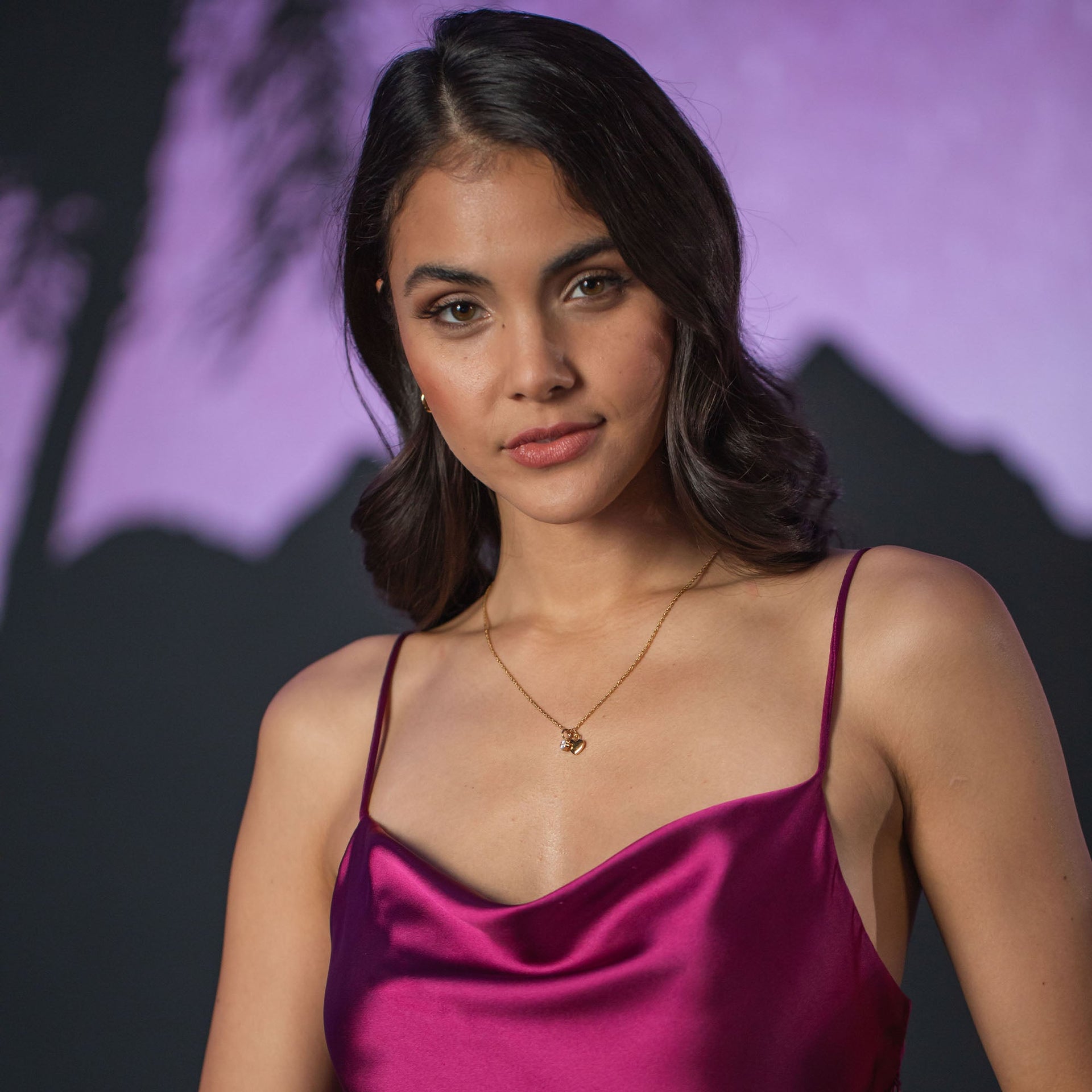 Elegante PURELEI Kette mit zartem Anhänger, getragen zu einem burgunderfarbenen Top.